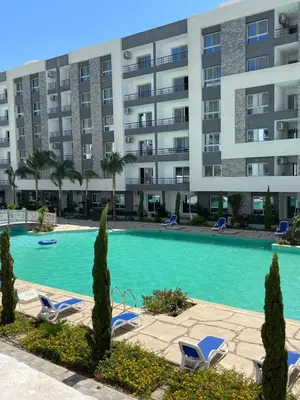 a swimming pool in front of a large apartment building at Fanadir Bay in Hurghada