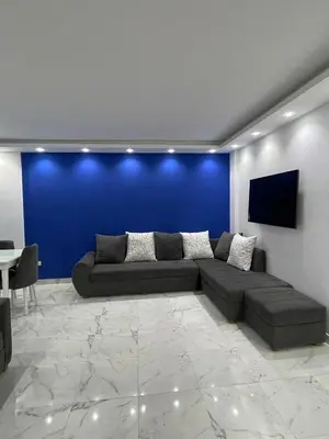 a living room with a couch and a blue wall at Fanadir Bay in Hurghada
