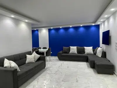 a living room with couches and a blue wall at Fanadir Bay in Hurghada