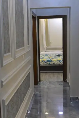 a hallway with a door leading to a room with a bed at برج النيل بزنس in Jazīrat al ‘Awwāmīyah