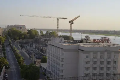 a view of a building with construction cranes at برج النيل بزنس in Jazīrat al ‘Awwāmīyah