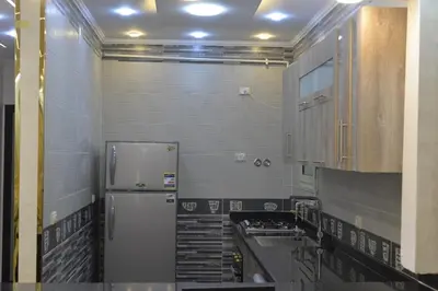 a kitchen with a refrigerator and a sink at برج النيل بزنس in Jazīrat al ‘Awwāmīyah