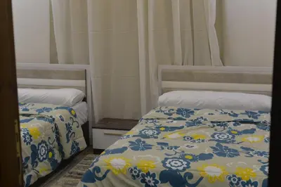 a bedroom with two beds with blue and white sheets at برج النيل بزنس in Jazīrat al ‘Awwāmīyah