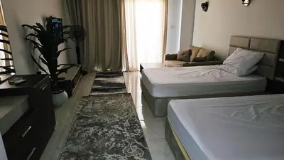 a small room with two beds and a couch at شاليه ب Selena Bay Resort in Hurghada