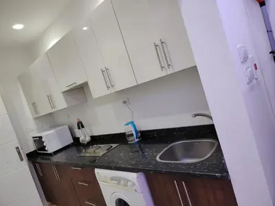a small kitchen with a sink and a washing machine at شاليه ب Selena Bay Resort in Hurghada