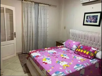 a bedroom with a bed with a pink blanket at Happy home in Hurghada