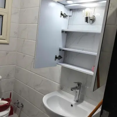a white bathroom with a sink and shelves at جوليانا بيتش ريزورت in Hurghada
