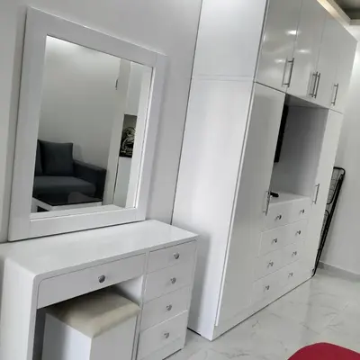 a white bedroom with a dresser and a mirror at جوليانا بيتش ريزورت in Hurghada