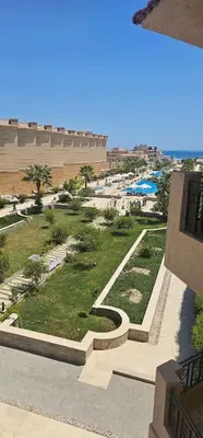 a view of a park with grass and a building at Selena Bay Resort Chalet in Hurghada