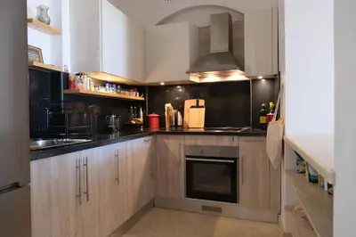 a kitchen with wooden cabinets and a stove top oven at Cozy Townhouse in West Golf - El Gouna in Hurghada