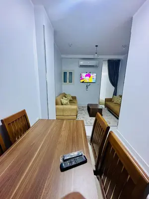 a room with a table with a remote control on it at Abbady tower in Jazīrat al ‘Awwāmīyah