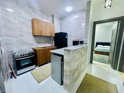 a kitchen with a stove and a counter top at Abbady tower in Jazīrat al ‘Awwāmīyah