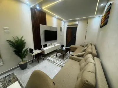 a living room with a couch and a flat screen tv at Moly House in Aswan