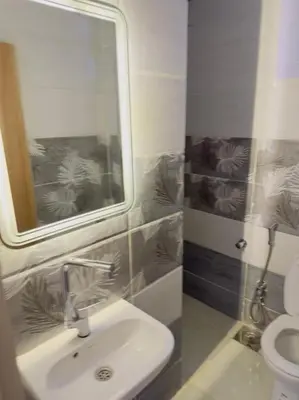 a bathroom with a sink and a mirror and a toilet at Moly House in Aswan