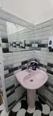 a bathroom with a sink and a mirror at Osama House Luxor in Al Qurnah