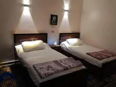 two beds in a room with lights on at Osama House Luxor in Al Qurnah