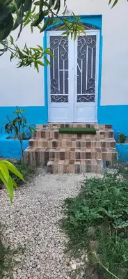 a door on a blue house with stairs in front at Osama House Luxor in Al Qurnah