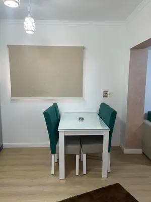 a white table and green chairs in a room at CC Luxurious Apartment in Hurghada