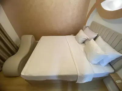 a bed with white sheets and pillows in a room at CC Luxurious Apartment in Hurghada