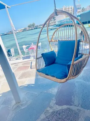a wicker chair with blue pillows sitting on a porch at CC Luxurious Apartment in Hurghada