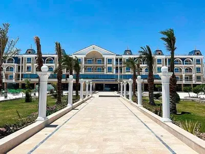 a large building with palm trees in front of it at Hurghada Hub in Hurghada