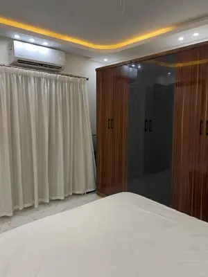 a bedroom with a bed and a tv and curtains at Hurghada Hub in Hurghada