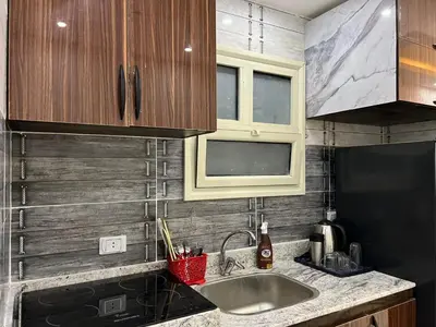 a kitchen with a sink and wooden cabinets at Hurghada Hub in Hurghada