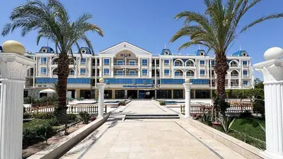 a large building with palm trees in front of it at Hurghada Hub in Hurghada