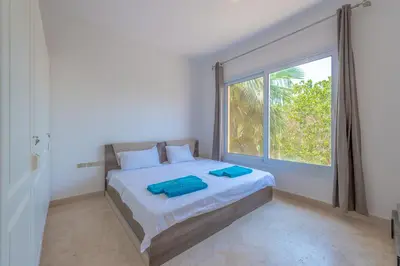 a bedroom with a bed and a large window at Cozy apartment with a pool in South Marina-Elgouna in Hurghada