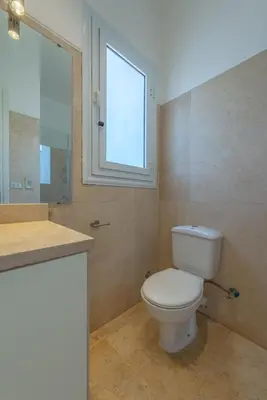 a bathroom with a toilet and a window at Cozy apartment with a pool in South Marina-Elgouna in Hurghada