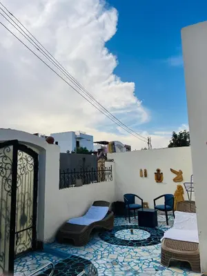 a balcony with chairs and tables on a building at private home lucky seven in Luxor