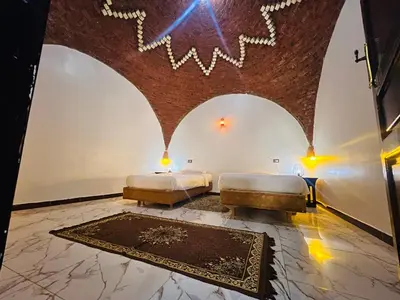 a room with two beds and a rug at private home lucky seven in Luxor