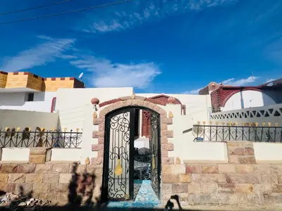 a white house with a black gate at private home lucky seven in Luxor