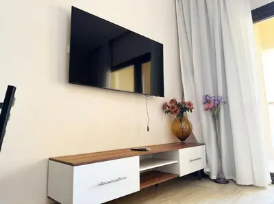 a television on a wall with a vase of flowers at Hula Hula piece of the sea in Hurghada