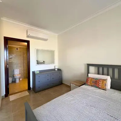 a bedroom with a bed and a sink and a mirror at Somabay Breezy Elegance 3BR Apartment in Hurghada