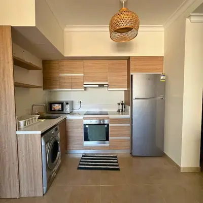 a kitchen with a stainless steel refrigerator and a dishwasher at Somabay Breezy Elegance 3BR Apartment in Hurghada