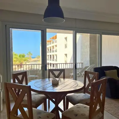 a table and chairs in a living room with a view at Somabay Breezy Elegance 3BR Apartment in Hurghada