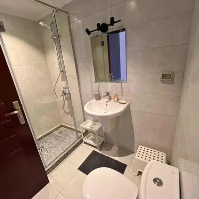 a bathroom with a shower and a toilet and a sink at Somabay Breezy Elegance 3BR Apartment in Hurghada