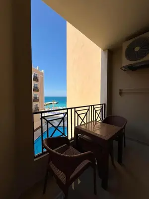 a balcony with a table and chairs and a view of the ocean at Juliana Beach Aqua park in Hurghada