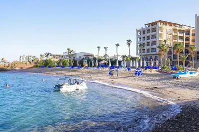 a boat in the water next to a beach at Juliana Beach Aqua park in Hurghada