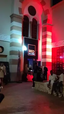 a group of people sitting in a building with a red sign at Camelgila Appartment Royal Residence in Port Ghalib