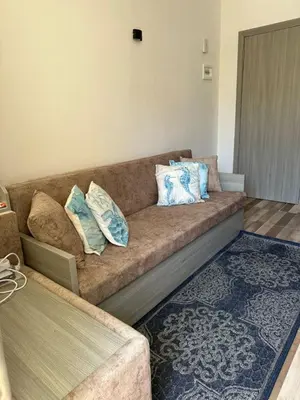 a couch in a living room with pillows on it at Camelgila Appartment Royal Residence in Port Ghalib