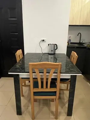 a kitchen table with chairs and a tea kettle on it at Two Bedroom Apartment in Lilly Land in Hurghada