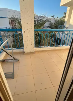 a balcony with a chair and a view of the ocean at Two Bedroom Apartment in Lilly Land in Hurghada