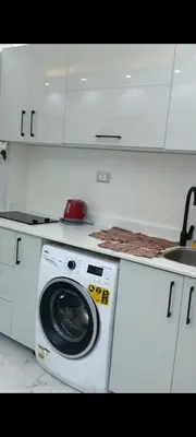 a white kitchen with a washing machine and a sink at Juliana beach in Hurghada