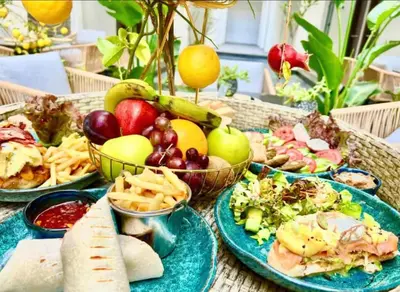 a table with plates of food on top at Lavish suite 97m wifi sea view apt boutique resort in Hurghada