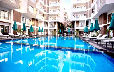 a swimming pool in a hotel with chairs and umbrellas at Lavish suite 97m wifi sea view apt boutique resort in Hurghada