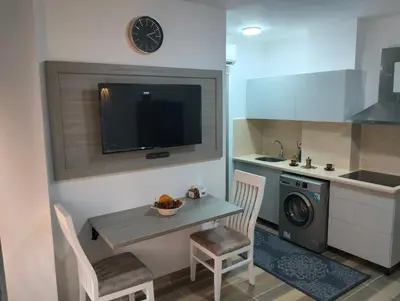a kitchen with a table and a sink and a clock at Petite Perle in Port Ghalib