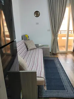 a small bedroom with a bed and a window at Petite Perle in Port Ghalib