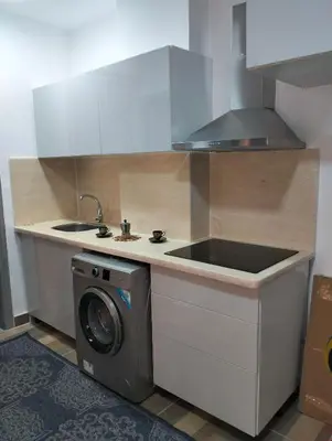 a kitchen with a sink and a washing machine at Petite Perle in Port Ghalib